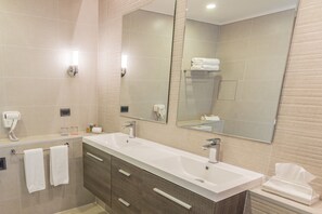 A modern bathroom with a large mirror, two sinks, and a towel rack. - MDS Hotel Chillan (Chillan)