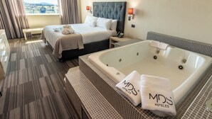 Une chambre d’hôtel avec un grand lit, une baignoire et une vue sur l’extérieur.