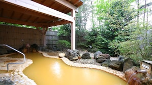 A hot spring area with a wooden deck, stone steps, and a wooden fence. - Towa Pure Cottages (Nasu)