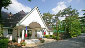 A white building with a green roof and a sign reading "Le Rosier". - Towa Pure Cottages (Nasu)
