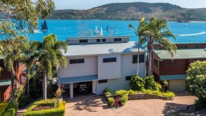 Ein Küstenhaus mit Meerblick, einer gepflasterten Auffahrt und einer Steinmauer mit dem Schriftzug "CASUARINA COVE".
