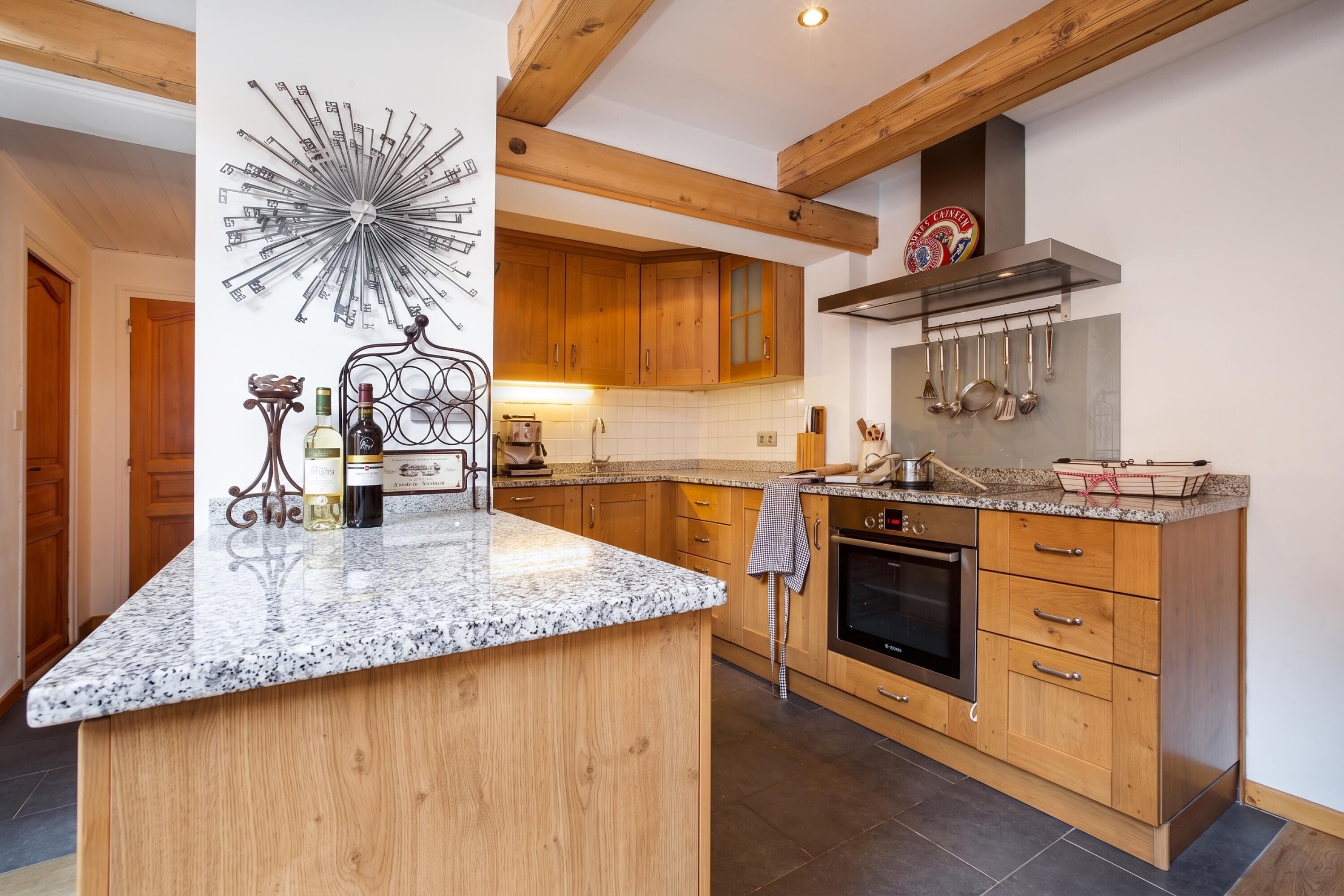Une cuisine moderne avec des meubles en bois, un plan de travail en granit et un four encastré.