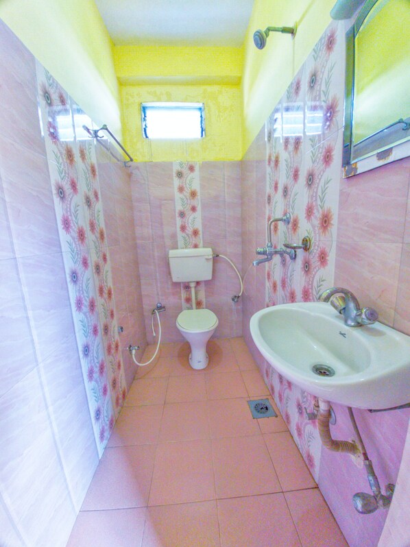 Un baño pequeño con inodoro, lavamanos y ducha.