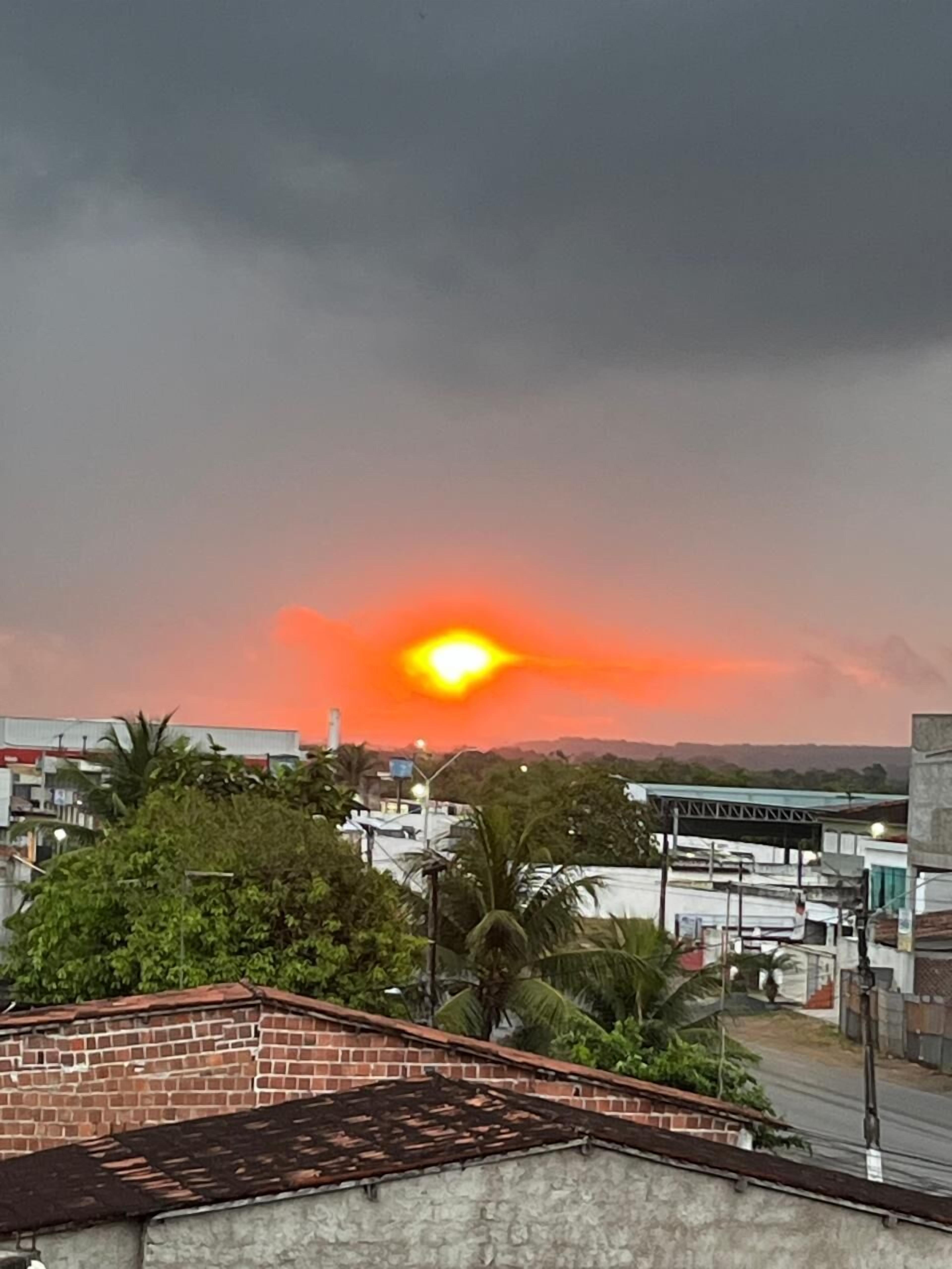 Atardecer sobre una zona residencial con edificios y vegetación.