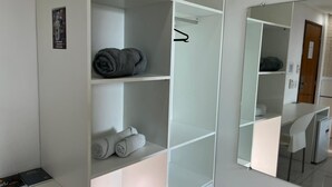 A hotel room with a white wardrobe, a mirror, and a desk. - Goiana Palace Hotel (Goiana)