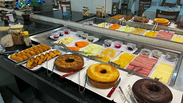 A buffet with various food items including cakes, fruits, and meats. - Goiana Palace Hotel (Goiana)