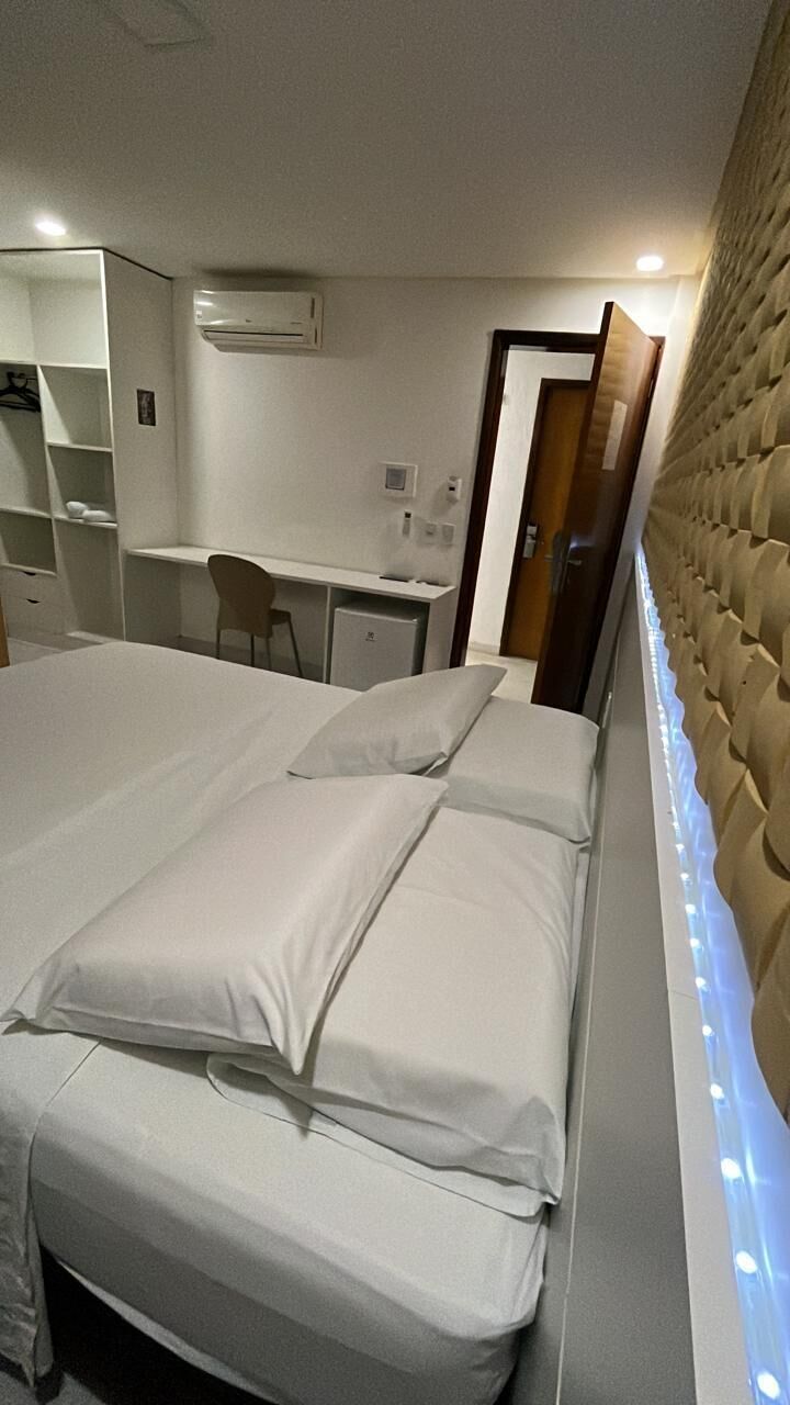 A hotel room with a bed, a desk, and a chair.
