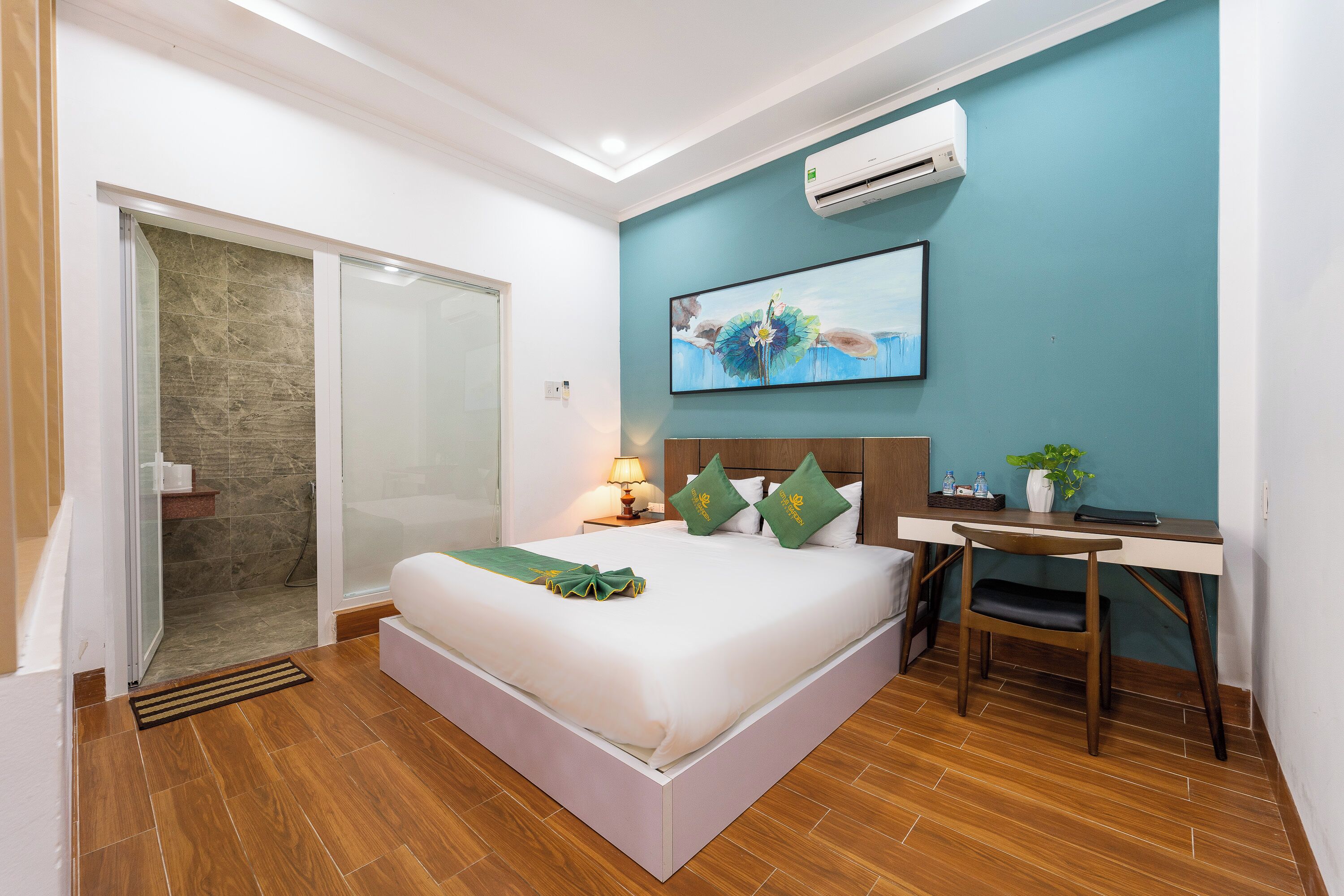 Habitación de hotel con cama, escritorio y un cuadro en la pared.