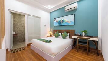 Habitación de hotel con cama, escritorio y un cuadro en la pared.