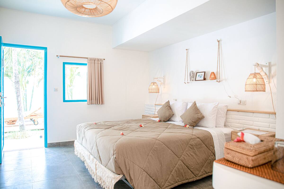 Une chambre avec un grand lit, une fenêtre avec des rideaux et une vue sur l’extérieur.