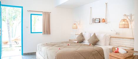 Une chambre avec un grand lit, une fenêtre avec des rideaux et une vue sur l’extérieur.