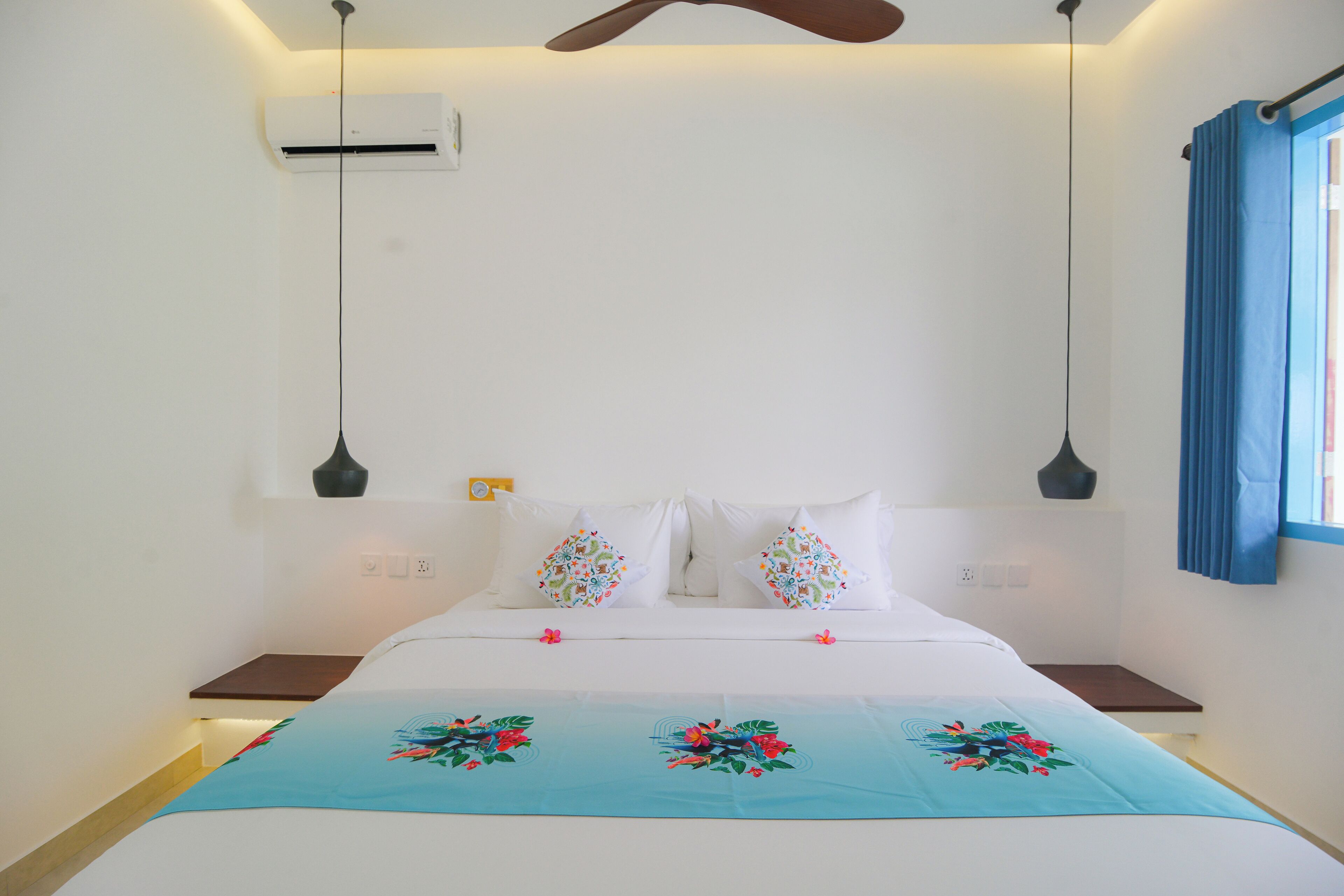 A bedroom with a bed, two nightstands, a ceiling fan, an air conditioning unit, and a window with curtains.