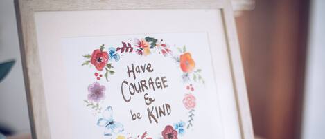A framed inspirational quote surrounded by colorful flowers.