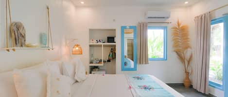 Un dormitorio con cama, armario, espejo y ventana con cortinas.