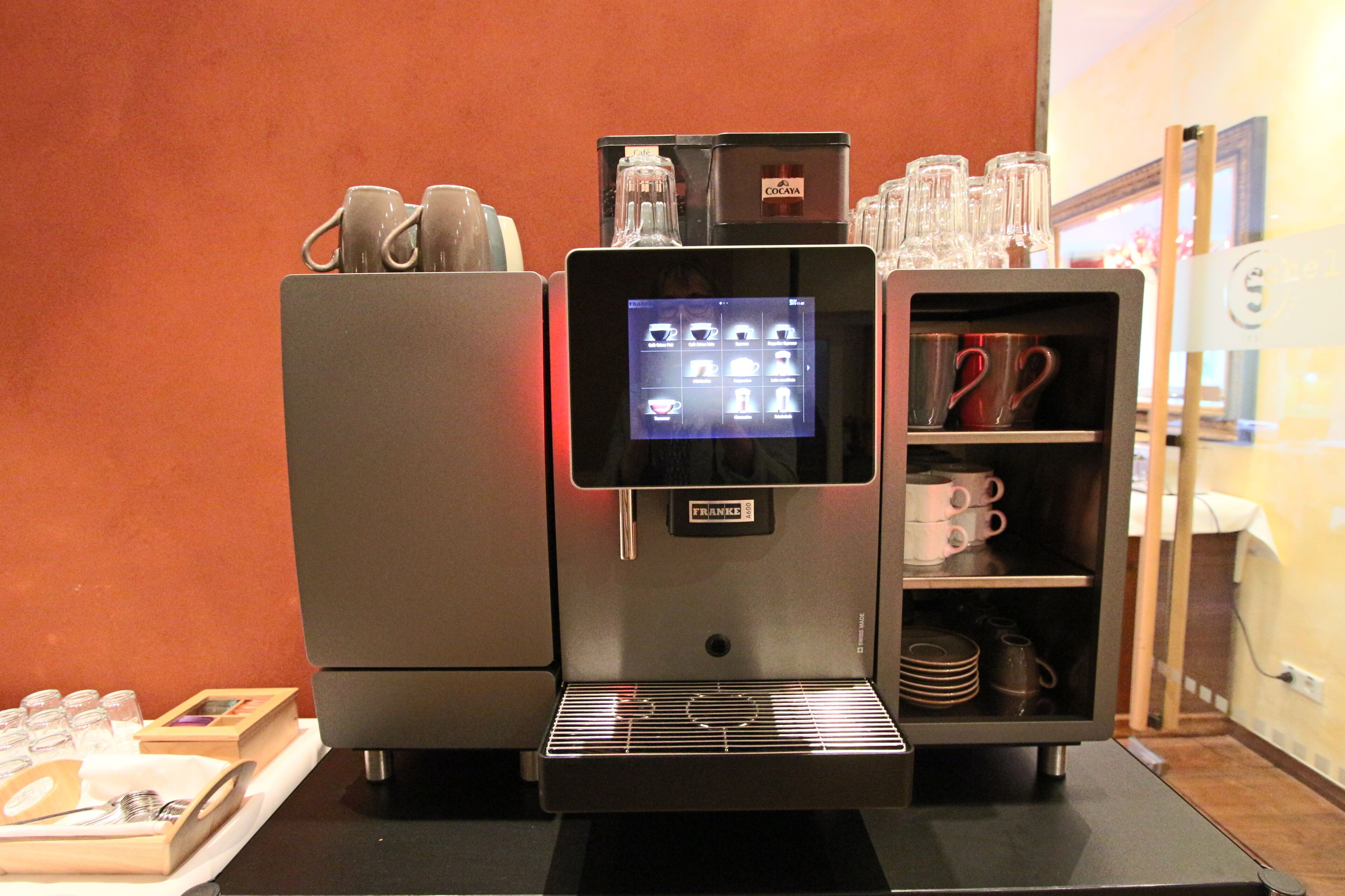 A coffee machine with a digital display and a coffee cup holder.