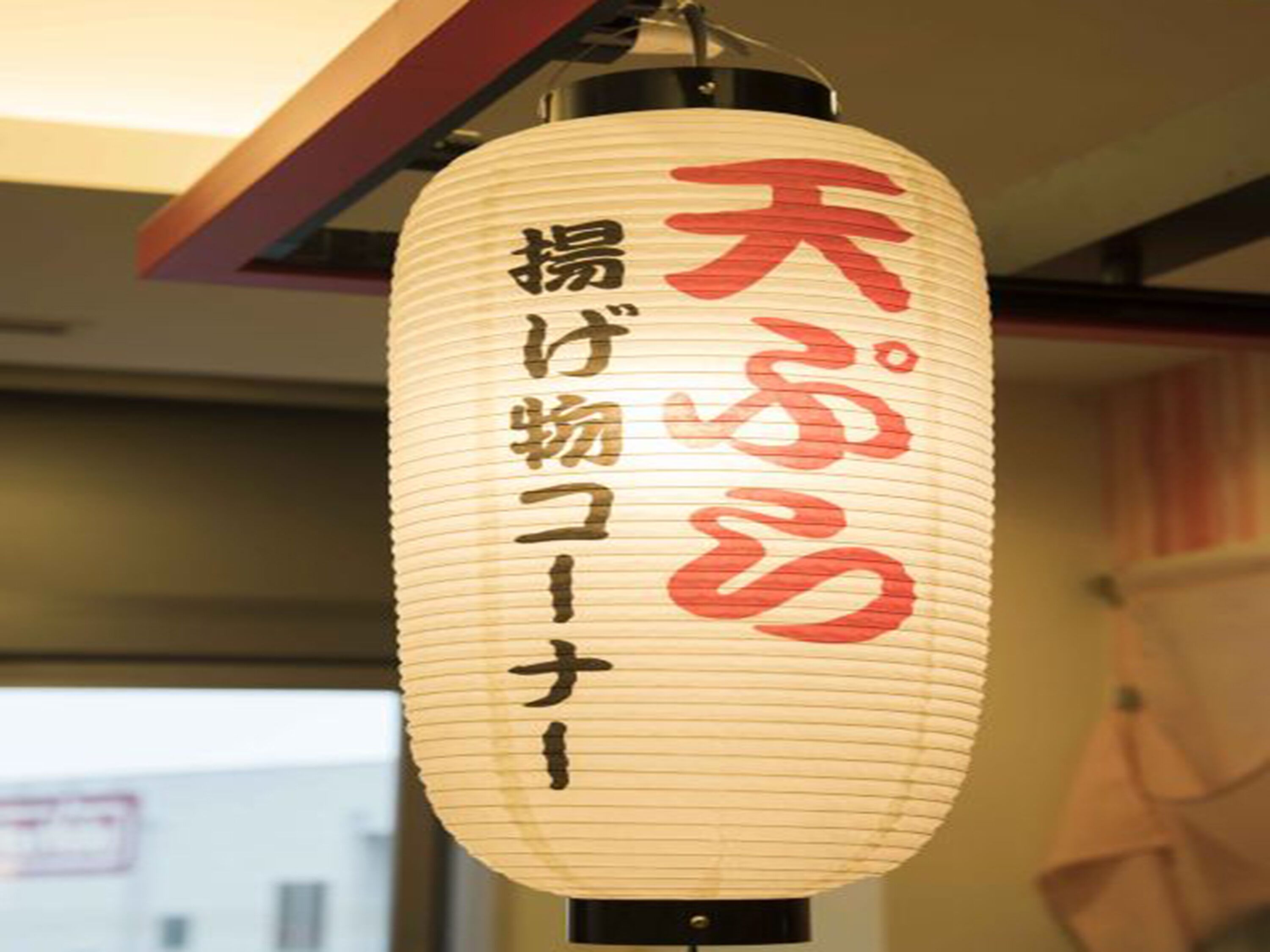 A hanging paper lantern with Japanese characters.