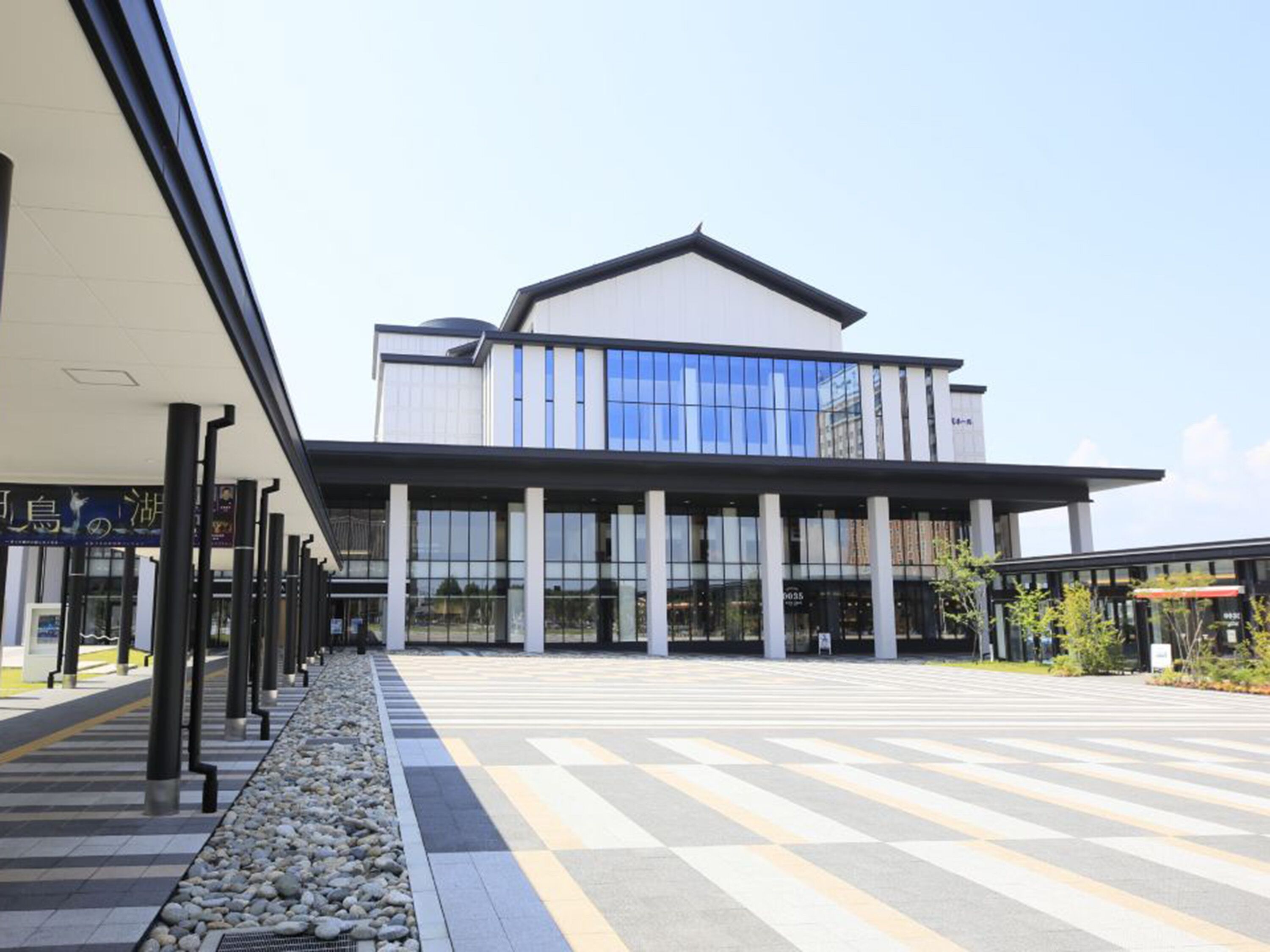 Un bâtiment moderne doté d’un toit plat et de grandes fenêtres.