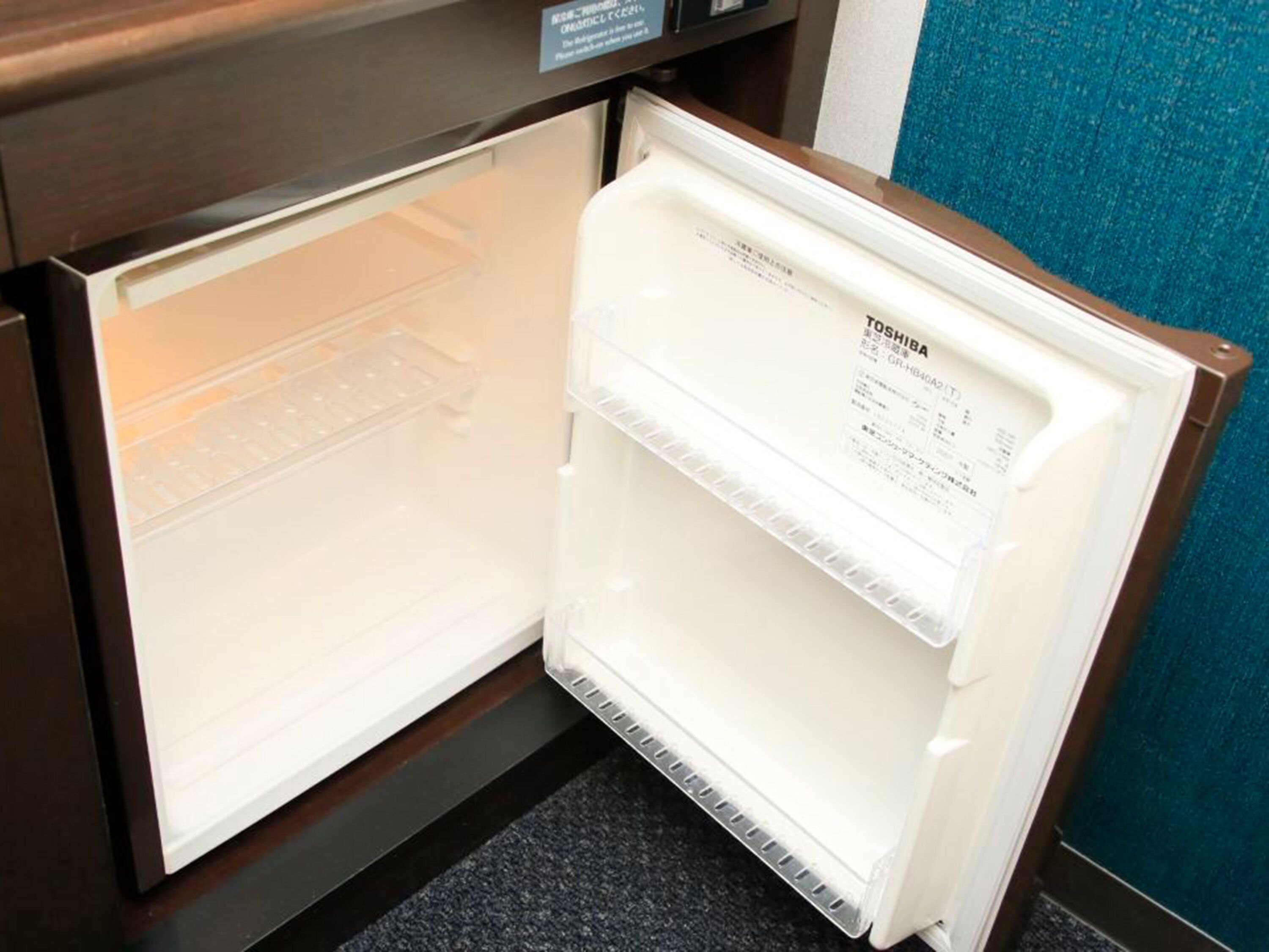 Un refrigerador abierto con una etiqueta que indica que es un modelo Toshiba.