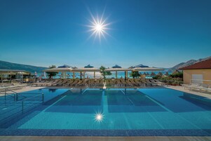 Una piscina al aire libre, camas de piscina gratis, sombrillas