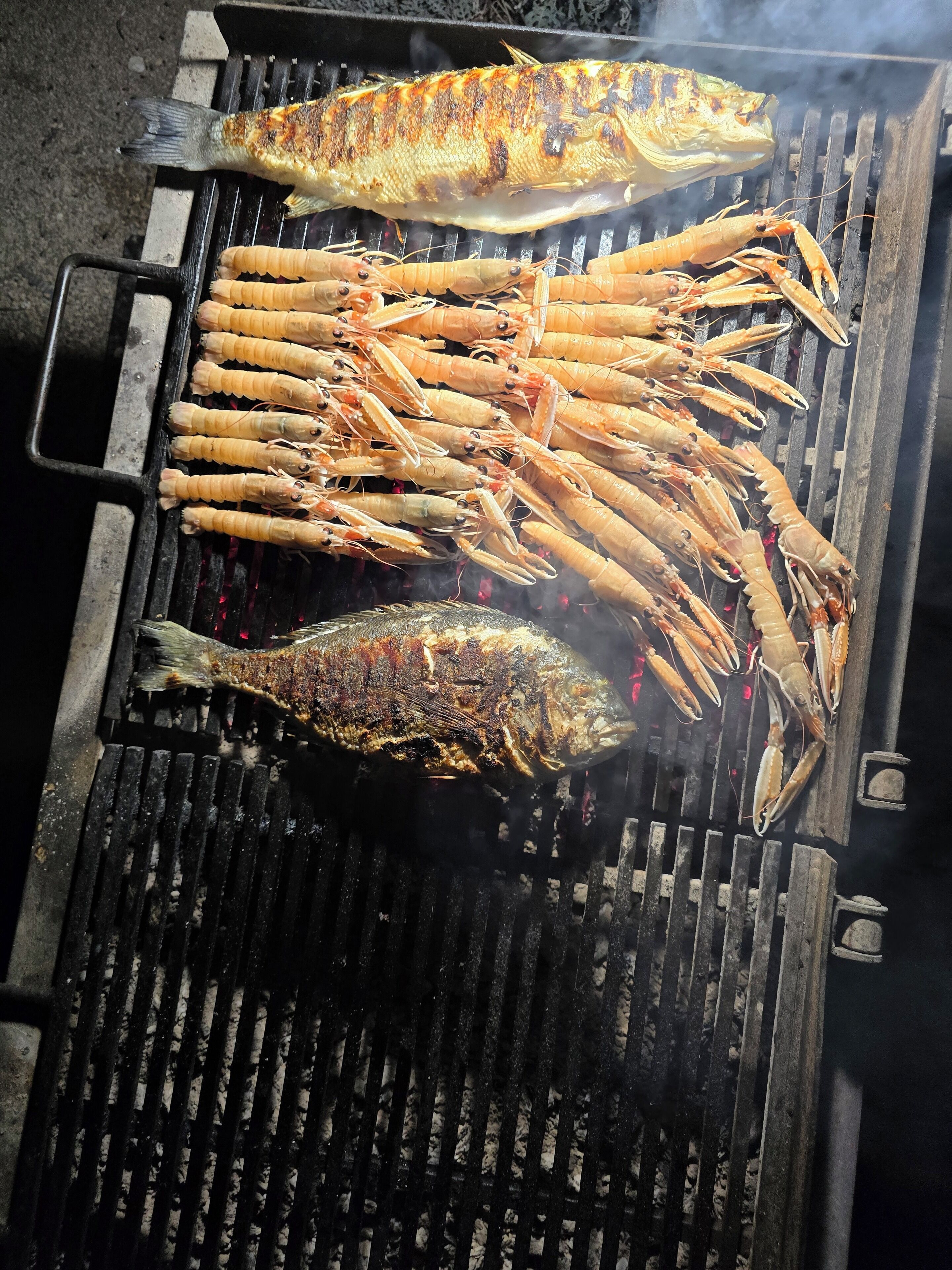 A grill with grilled fish and shrimp.