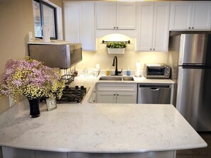 Een koelkast, een microgolfoven, een kookplaat, een vaatwasser