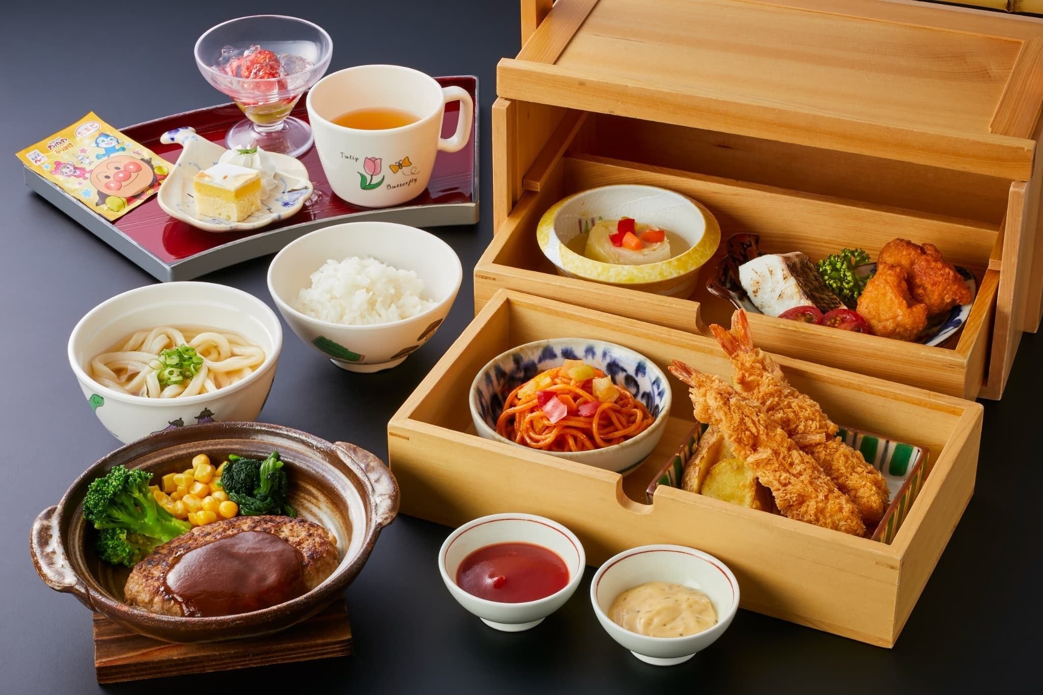 Un repas japonais traditionnel composé de différents plats, notamment du riz, des nouilles et des beignets de tempura, servis sur un plateau et dans une boîte en bois.