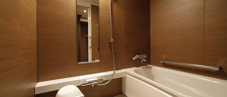 A modern bathroom with a bathtub, a shower, and a toilet.