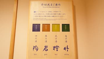 A framed sign with Japanese text and color-coded sections, likely indicating room usage times or guidelines.