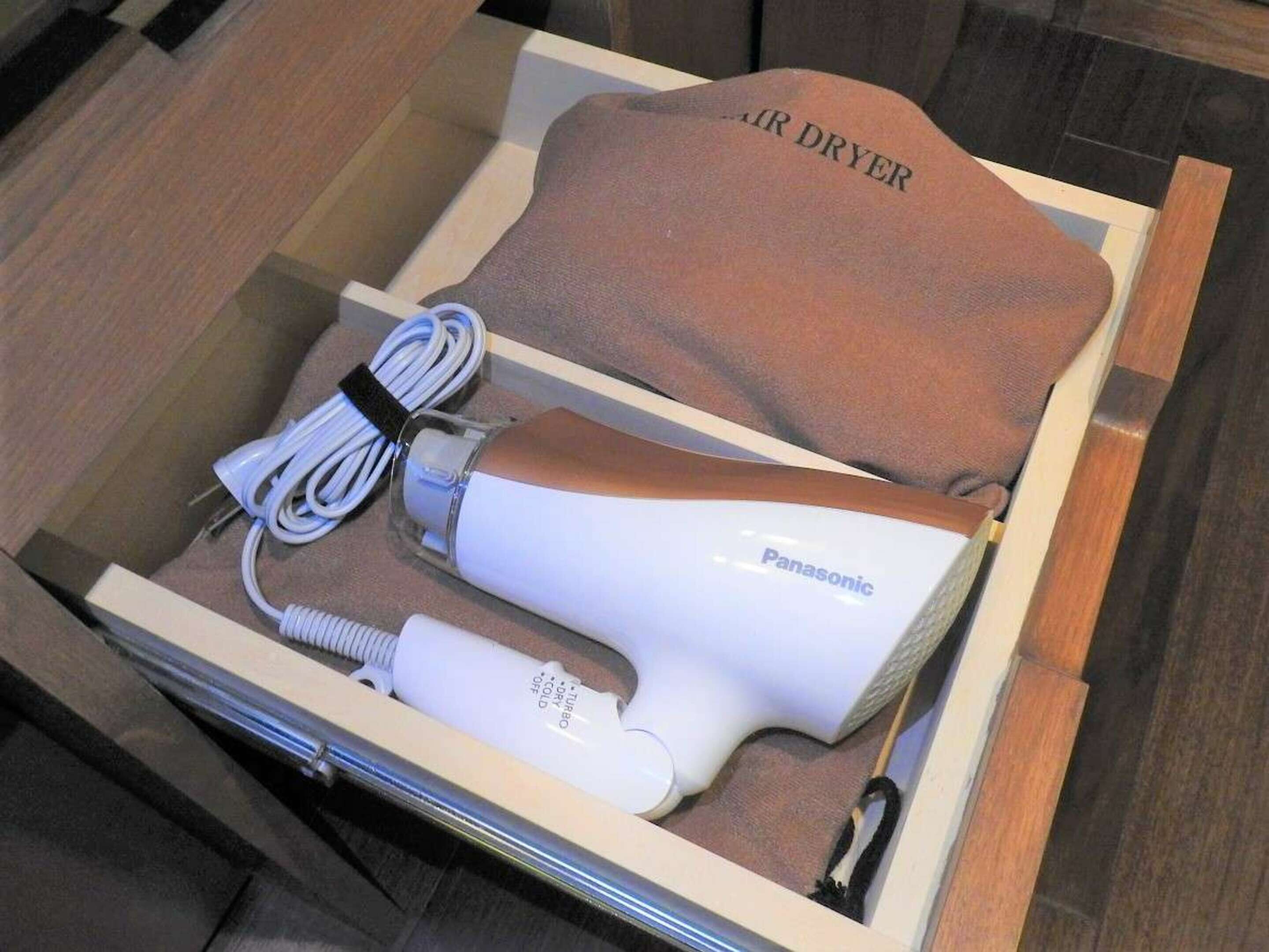 Un secador de pelo Panasonic en una caja de madera con un paño marrón que dice 'AIR DRYER'.