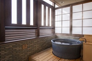 A traditional Japanese-style room with a wooden floor, a large wooden window with sliding shoji screens, and a hot tub. - Kotohira Onsen Onyado Shikishimakan (Kotohira)