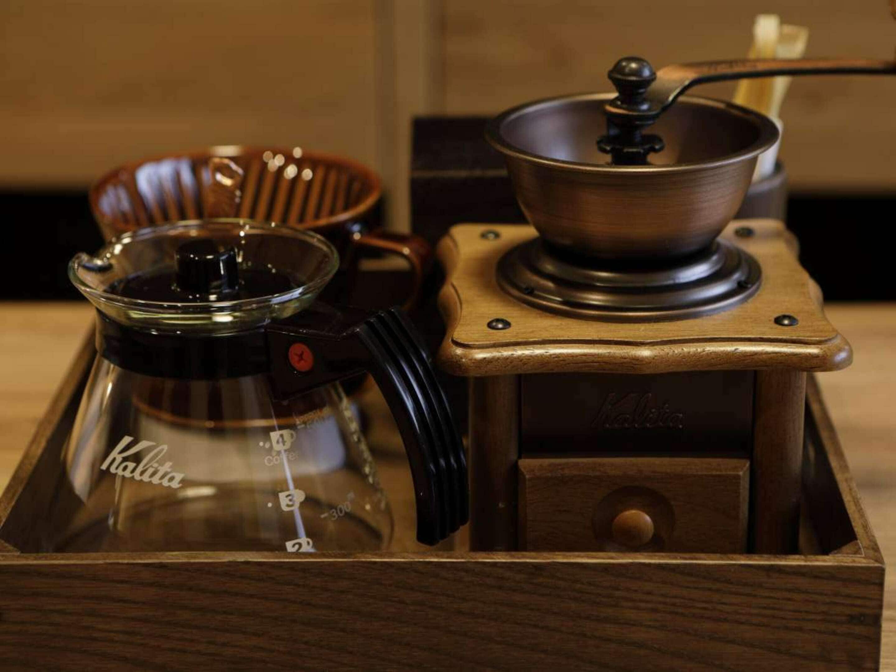 A coffee maker and a coffee pot on a wooden table.