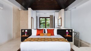 A modern hotel room with a large bed, dark wooden ceiling, and a view of greenery outside. - Sugar Kube Villa Turks & Caicos – Romantic 1BR Villa with Private Pool & Rooftop Deck (Grace Bay)