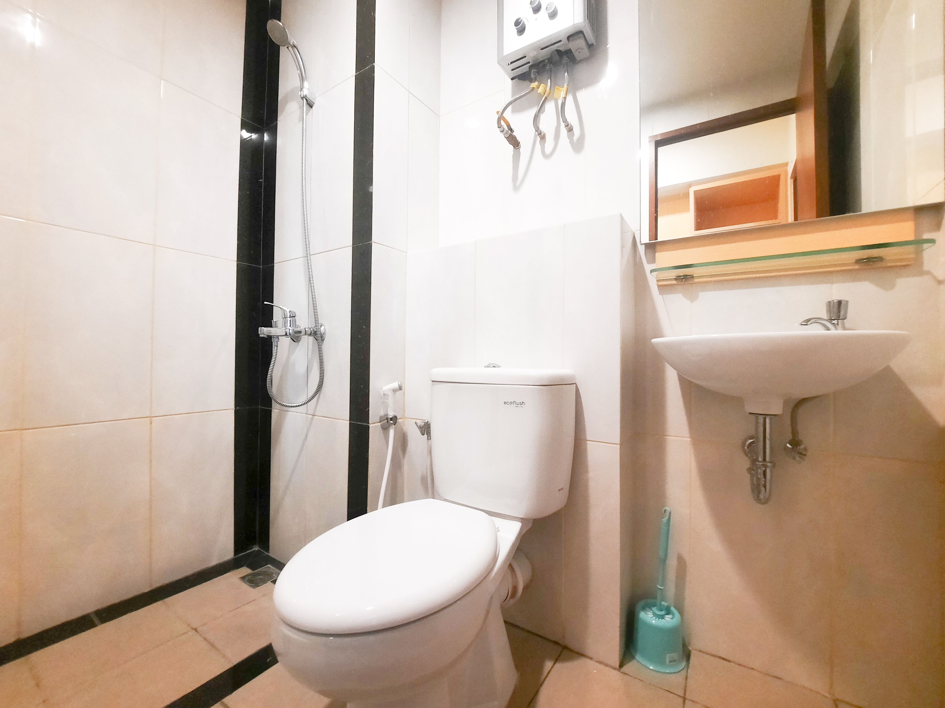 A bathroom with a toilet, a shower, and a sink.