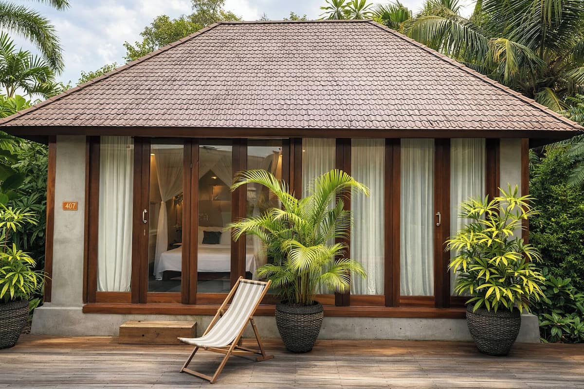 A bungalow with a tiled roof, large windows, and a wooden deck.