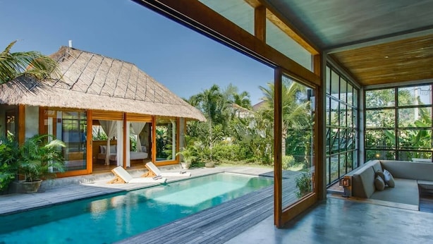 A modern villa with a pool, large windows, and a thatched-roof structure. -  ZIN Berawa Villas & Bungalow (Tibubeneng)