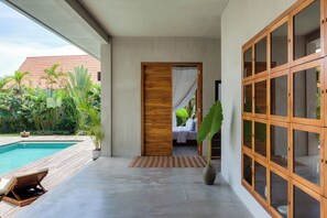 A modern villa with a pool, a bedroom with a canopy, and a large wooden cabinet. -  ZIN Berawa Villas & Bungalow (Tibubeneng)