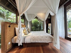 A bedroom with a canopy bed, wooden headboard, and large windows with curtains. -  ZIN Berawa Villas & Bungalow (Tibubeneng)