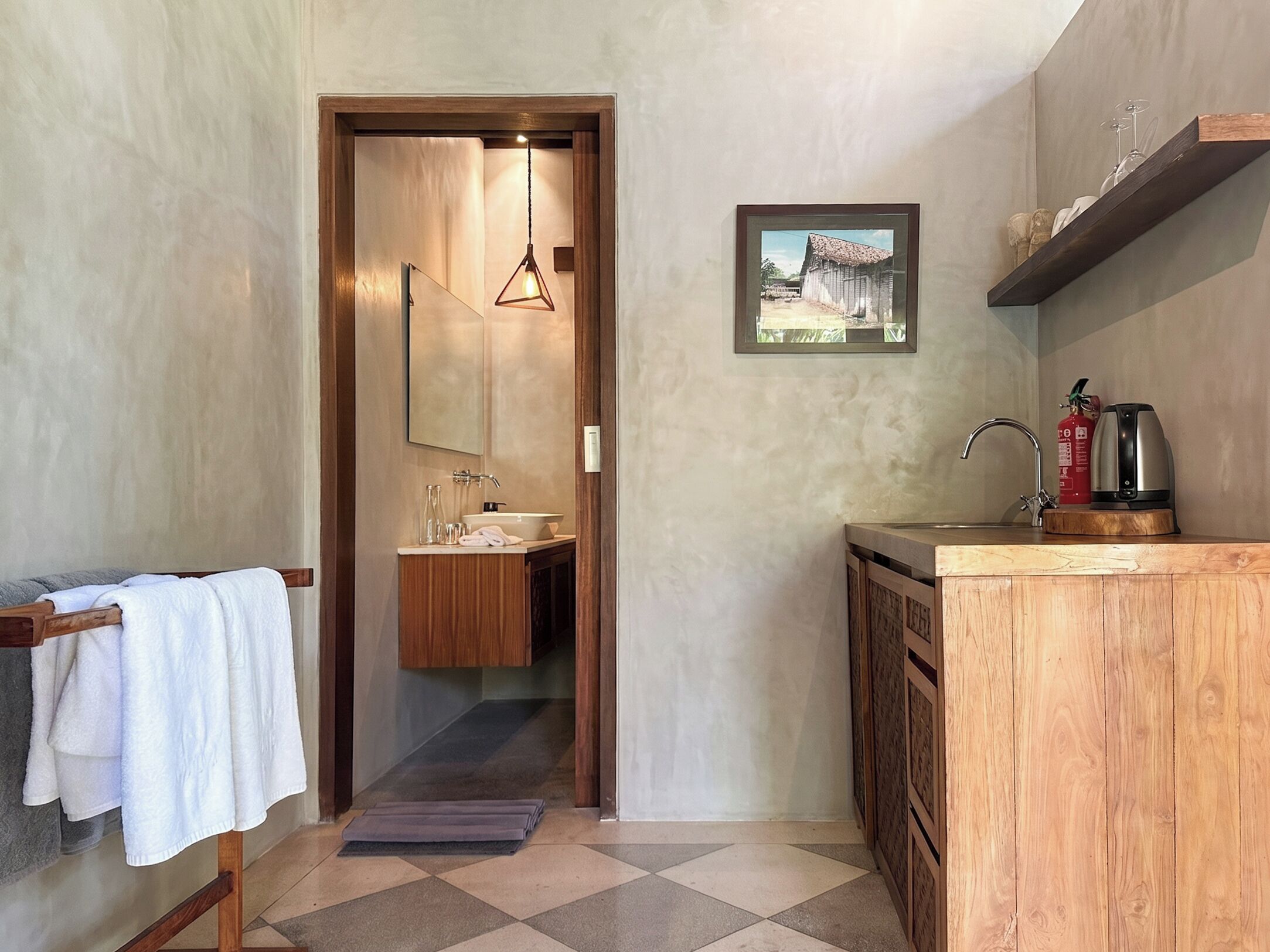 A bathroom with a wooden vanity, a sink, a mirror, and a framed picture on the wall.