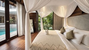A bedroom with a large bed, white curtains, and a view of a pool. -  ZIN Berawa Villas & Bungalow (Tibubeneng)