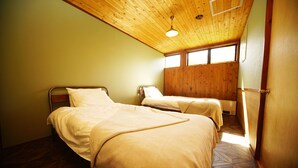 A room with two beds, wooden ceiling, and a window providing natural light. - HAKUBA Lodge OMUSUBI (Otari)
