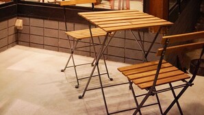 A room with a wooden ceiling, a dining table with chairs, and a view into another room with a kitchen. - HAKUBA Lodge OMUSUBI (Otari)