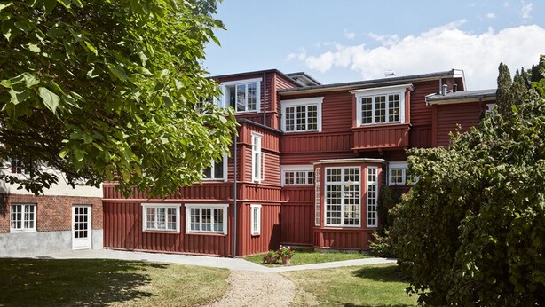 A red wooden building with multiple windows and a brick section. - Hotel Hornbækhus (Hornbaek)