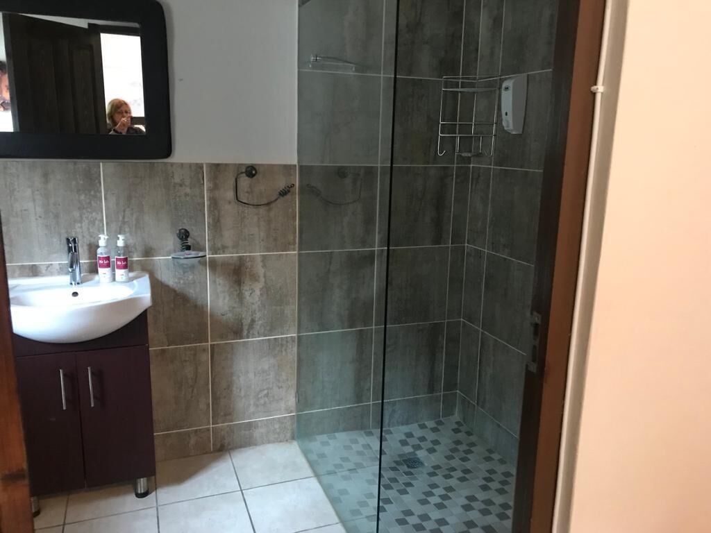 Une salle de bain équipée d’un lavabo, d’un miroir et d’un espace douche.