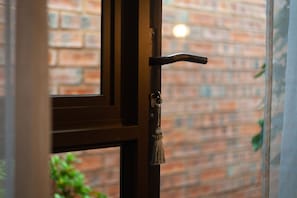Une porte dotée d’une poignée en laiton et d’un trou de serrure, le tout se détachant sur un mur en briques.