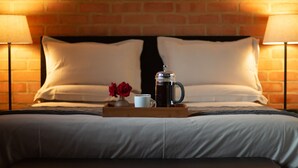 A neatly made bed with white linens, a tray with a coffee pot, a mug, and two red roses. - Twin Rivers Bed and Breakfast (Centurion)