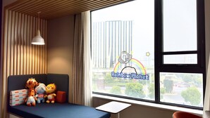 Quarto com vista para a cidade, um brinquedo de pelúcia em um banco e uma pequena mesa.
