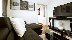 Una sala de estar moderna con un sofá modular, una mesa de centro de vidrio y un televisor de pantalla plana.