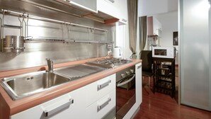 Una cocina moderna con electrodomésticos de acero inoxidable, encimera de madera y horno empotrado.