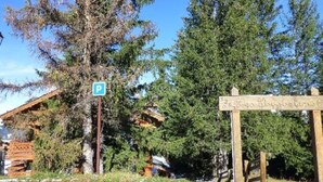 A wooden signpost with a parking symbol and a sign indicating a mountain resort. - Rustic apartment in Courchevel, near slopes (Courchevel 1850)