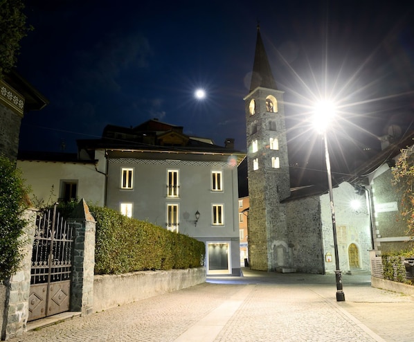 A historic building with a tower, cobblestone courtyard, and a gated entrance. - Hotel San Vitale (Bormio)